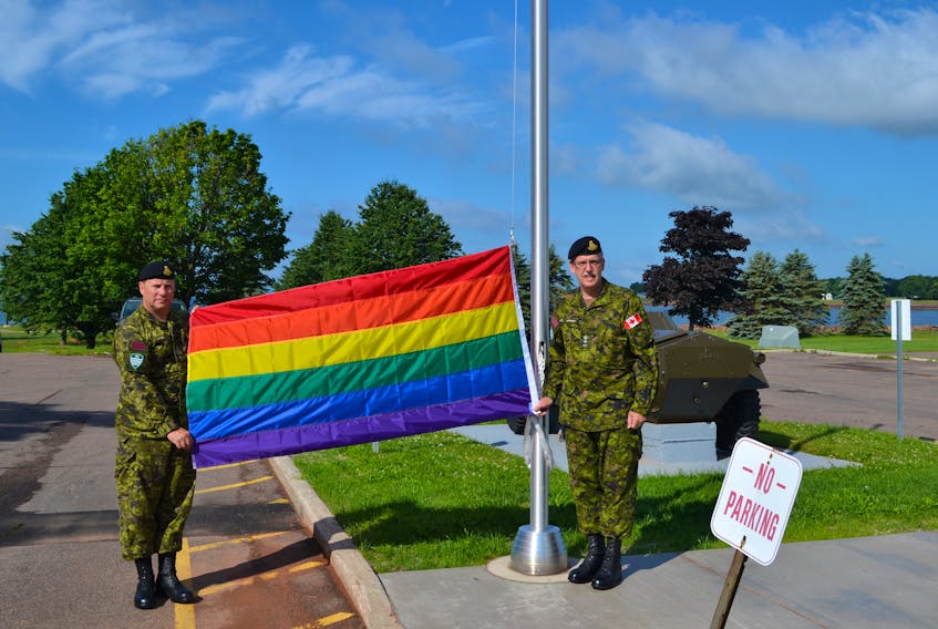 Commanding officer of the Prince Edward Island Regiment (RCAC), Lt.-Col. Glenn Moriarity, right, and the regimental sergeant major, CWO Bill Crabb raise the Pride flag at the Queen Charlotte Armoury in Charlottetown to recognize the beginning of Pride Week on P.E.I.
