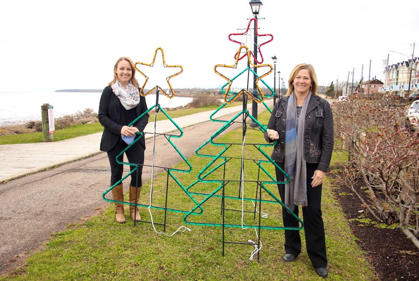 Angie Arsenault, left, executive director of Downtown Summerside Inc., and Heather Matheson, managing director of the Prince County Hospital Foundation with one of more than 30 new Christmas displays that are being installed along Summerside's waterfront boardwalk as part of the annual Lights for Life campaign.