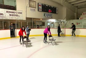 Krista Locke-Ellis, executive director of the Western Region Sport and Recreation Council, left, watching the second group of newcomers practice skating for the first time.