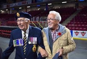 Veteran George Olscamp, 100, laughs with son, David, after the 2019 Remembrance Day ceremonies at Credit Union Place, Summerside.