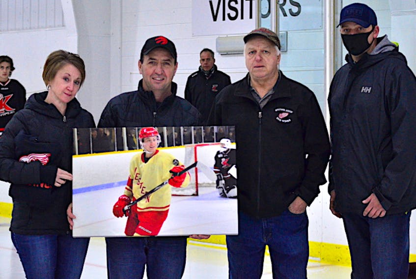 Darren and Glenda Hutchinson were presented with a photograph of their son, Alex, in action with the Western Red Wings of the Island Junior Hockey League last season. The Red Wings retired Alex's number on Sunday night. Red Wings owner Robert Arsenault, second right, and general manager JC Gallant, right, made the presentation during a pre-game ceremony before the team’s home opener against the Kensington Vipers. The photo is from a game the Red Wings played at the O’Leary Community Sports Centre – Alex’s home arena.