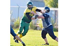The Summerside Clippers’ Landon Gallant fends off a block by a Charlottetown Privateer during a Papa John’s P.E.I. Varsity Tackle Football League game.