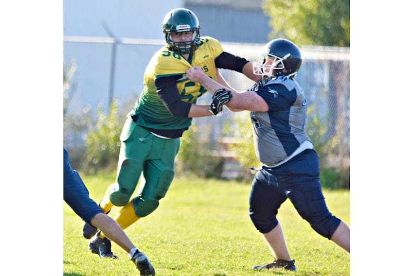 The Summerside Clippers’ Landon Gallant fends off a block by a Charlottetown Privateer during a Papa John’s P.E.I. Varsity Tackle Football League game.