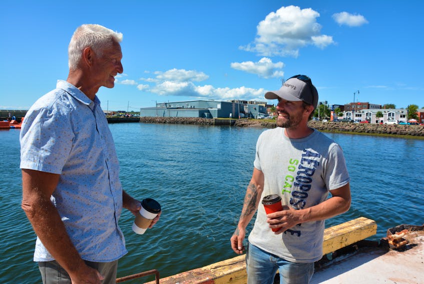 Brian Levesque, left and John Waddell meet at Summerside’s Holman’s Wharf Wednesday afternoon. Both men jumped into the water Tuesday morning to pull a man from a sinking car.