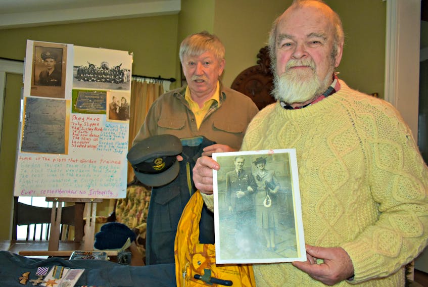 George Dalton, from left, and Randy Ross have a large and varied collection of war and military memorabilia that they hope will find a permanent home in a local museum. Ross holds a faded black and white picture of pilot officer James Harry Waugh and his wife. Waugh had an astounding escape when his parachute failed to open at 3,000 feet above Germany during the Second World War. As his aircraft hit the ground, the explosive aftermath caused the Wilmot Valley man to soar back into the sky and eventually land safely on his feet.