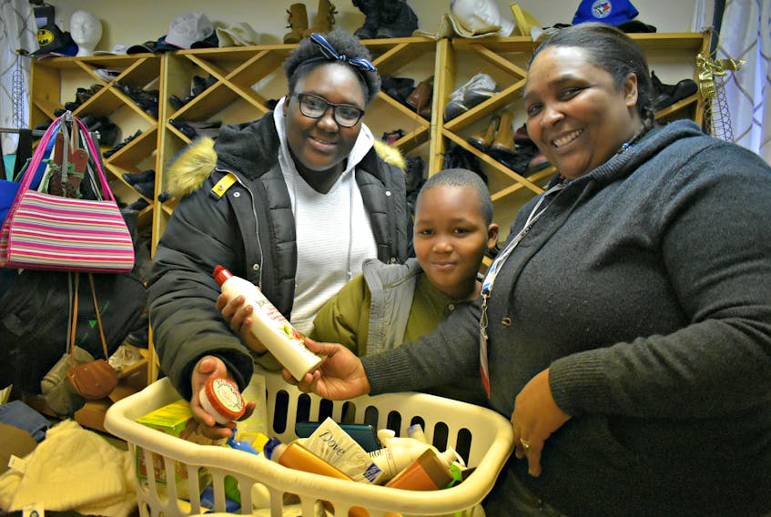 Trecia Graham, from the right, with her two children Davia, left, and Davaughn volunteers and shop at the Free Store in Summerside.
