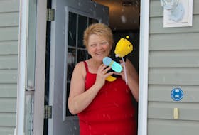 Kim Baglole is shown with her bee bear outside her Southwest Lot 16 home. Baglole started an online activity called P.E.I. Bear Hunt where Islanders put teddy bears in their windows, and parents can go for a drive with their children and try to spot as many as they can.