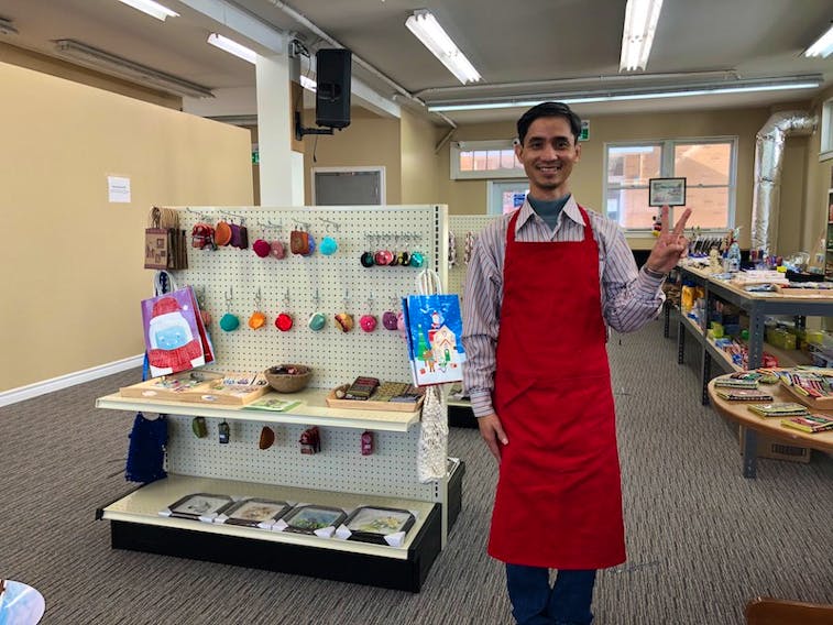 Nguyen Ba Dai Cao stands next to a crafts display at his business, G&T Book Café in Summerside.