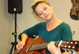 Trinity Bradshaw playing a song on the guitar.