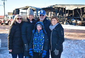 Chantel Noye, from left, Crystal MacKendrick, Ronnie Mackendrick, Bryan MacKendrick, and Amy MacKendrick watch as the last hot spots are doused and the black smoke wafting through the remaining steel frame of the Tyne Valley Community Sports Centre is tamed by firefighters.
