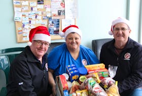 Central P.E.I. Kinette Club co-chairmen Ray McCourt, left, Sue Gallant and Eric Ferrish hold up a KIN Christmas hamper.