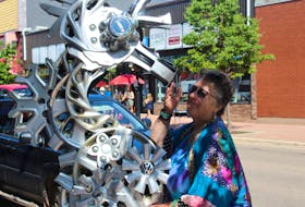 Artist Georgina Markov and her hubcap seahorse sculpture at the Summerside Art Festival.