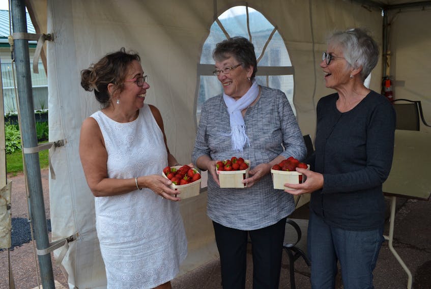 Residence manager Colleen Parker, left, and members of the ladies' auxiliary, Shirley Wallace and Leona Lane, sample berries provided for the home’s annual open house and strawberry and ice cream social. The auxiliary provided $500 towards the rental of the events tent for the social and regularly supports events for the benefit of the residents at Alberton’s Rev. W.J. Phillips Residence. Several local entertainers volunteered their time for the program.