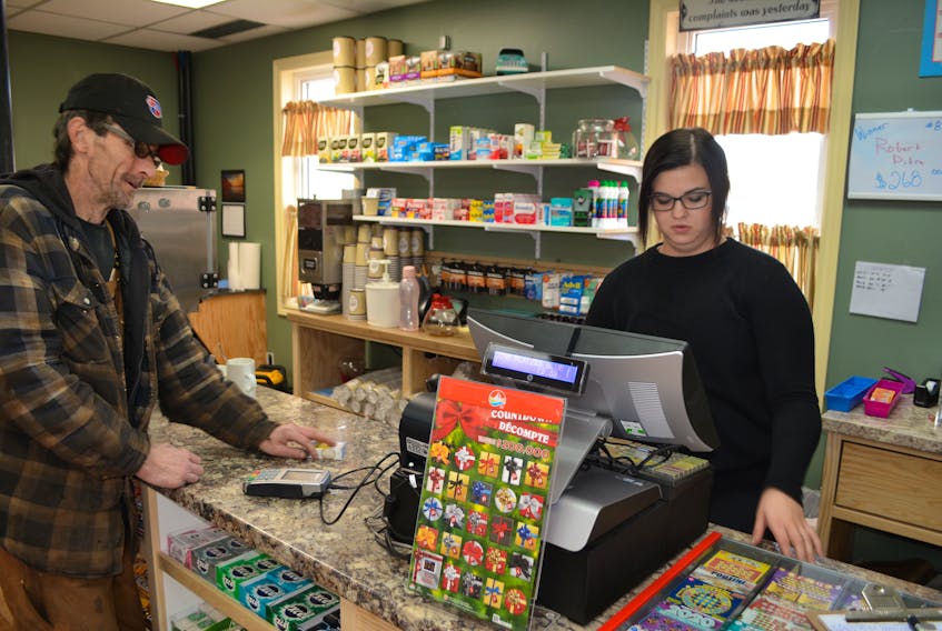 Richard Carr gets his order filled by Eugene’s General Store cashier Brittany Doyle. A makeshift store opened in Tignish on Nov. 8 and it will continue to operate during the construction of a new store to replace the one that was destroyed in a Sept. 29 fire. 
Eric McCarthy/Journal Pioneer