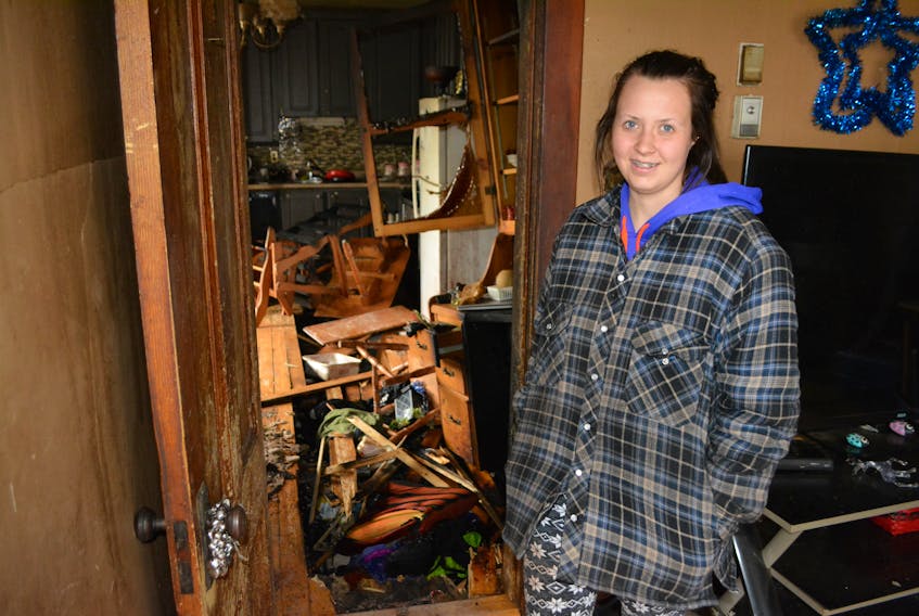 Isabel Getson surveys the fire-damaged kitchen of the Tignish home she shared with her parents and grandmother. Part of the kitchen floor collapsed into the basement during the Monday afternoon fire. Eric McCarthy/Journal Pioneer