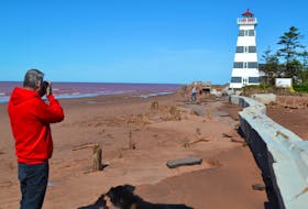 Photographer Lowell Palmer joins other beach-goers in capturing photos to document how hurricane Dorian has altered the look of the West Point beach beside the West Point Lighthouse.