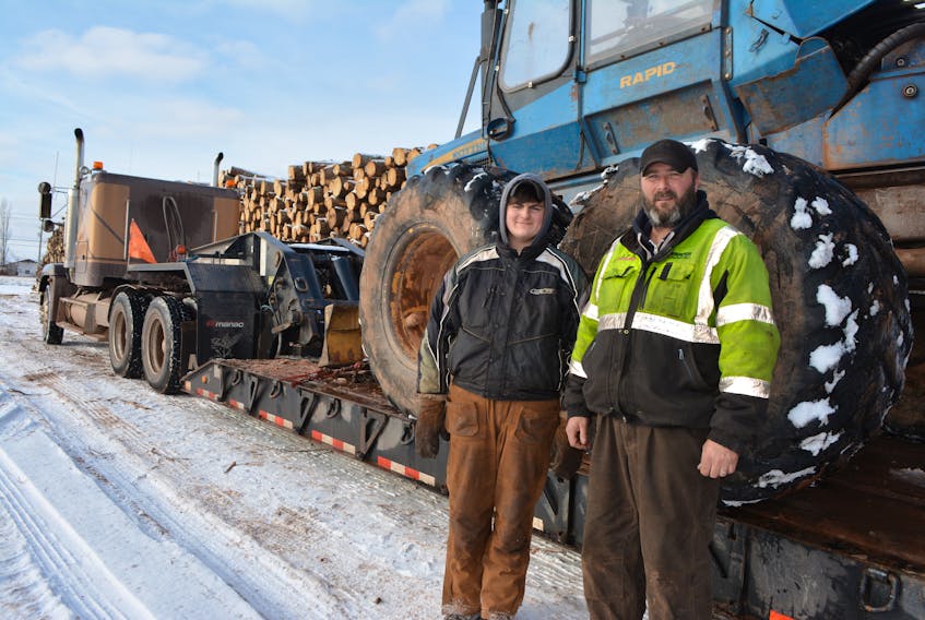 Jamie Wallace, right, owner of Jamie Wallace Forestry, and his son, Aidan, prepare to float a porter, also known as a forwarder, from a woodlot in Montrose. Wallace has decided to cease operations until forestry prices rebound. 
Eric McCarthy/Journal Pioneer