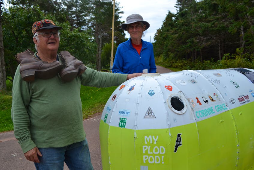 Henry Gallant, left, who walked across Canada as a centennial adventure 52 years ago, welcomes Richard Zier-Vogel to his Nail Pond, P.E.I. home. Zier-Vogel is nearing the end of his cross-Canada walk. Gallant, displaying the cap and hiking boots he used in his subsequent walk across Europe, did his centennial walk carrying a 25-Kg pack while Zier-Vogel is doing his in running shoes and pulling a 75-Kg plod pod he built.