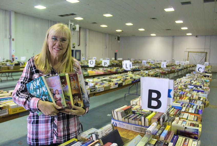 Anna MacDonald, a coordinator with the annual Journal Pioneer and Rotary Club of Summerside Book Sale for Literacy, shows off some of what the sale, which starts Thursday, has on offer.