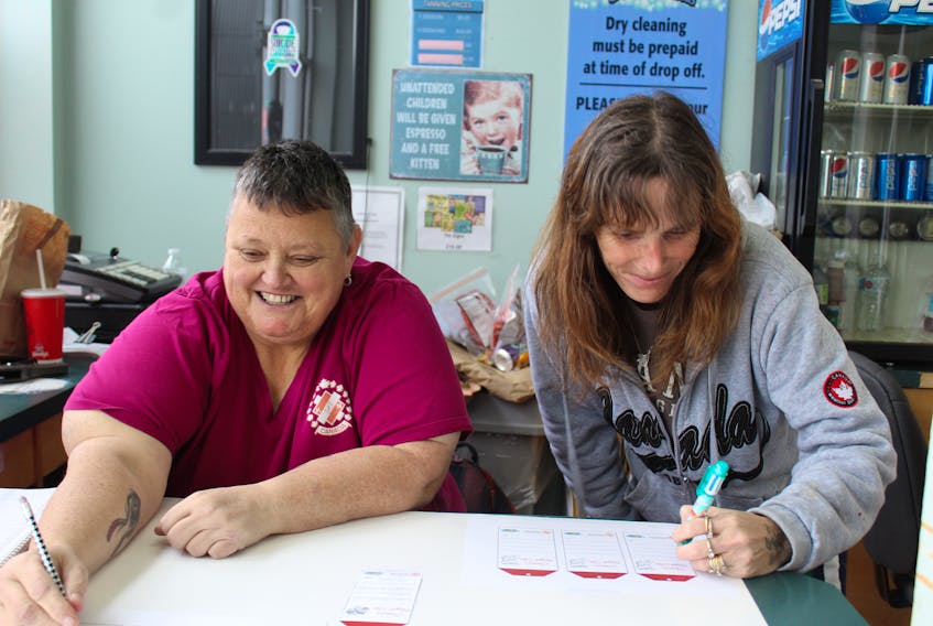 Sue Gallant, left, and Lisa Corbett fill out tags for the Seniors Angels initiative.