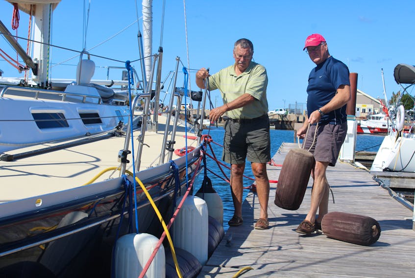 Glen Grant, left, and Blair Campbell work to secure a vessel docked at the Summerside marina in preparation for Saturday’s expected tropical storm