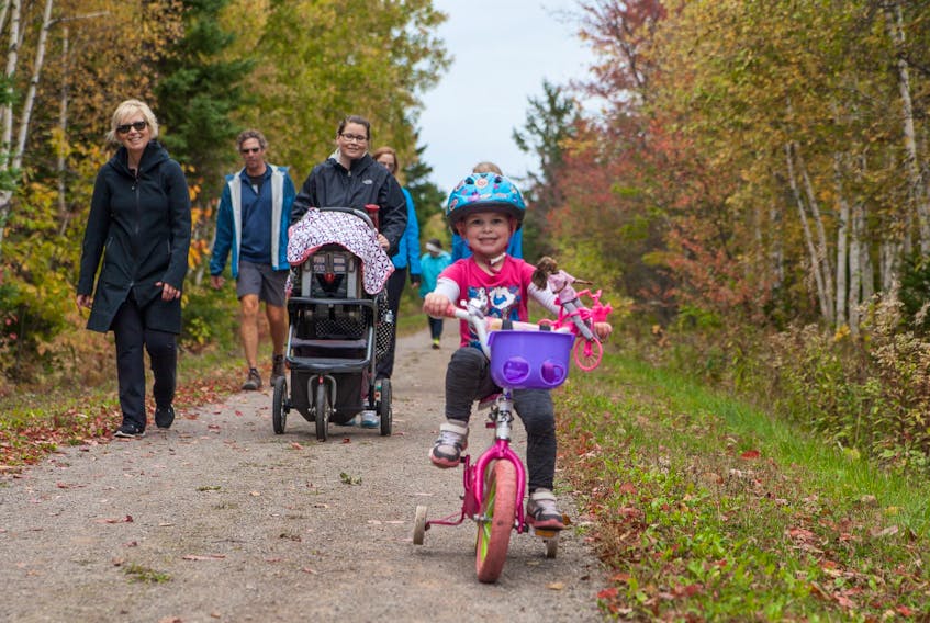 Dilyn Stewart peddles along as Becky Stewart, right, and Sarah Millar, left, follow along from behind during the 2018 Esther Finkle Fund’s Walk for Kids.