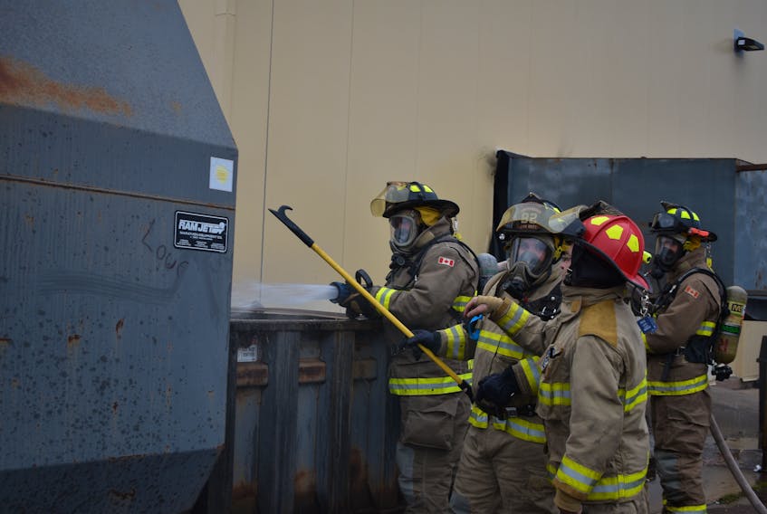 Summerside firefighters spray water into the trash compactor at Wal-Mart on Nov. 18. The fire was contained inside the unit by the store's sprinkler system.