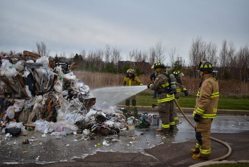 Summerside firefighters spray water into the trash compactor at Wal-Mart on Nov. 18. The fire was contained inside the unit by the store's sprinkler system. Crews couldn't get in to the unit to tackle the cause, so Superior Sanitation staff opened the container onto the pavement a safe distance away. Firefighters extinguished the smouldering debris in the parking lot. The store was evacuated as a precaution. Store sprinklers were soaking the inside of the machine. Customers were allowed back inside around 4:15 p.m.