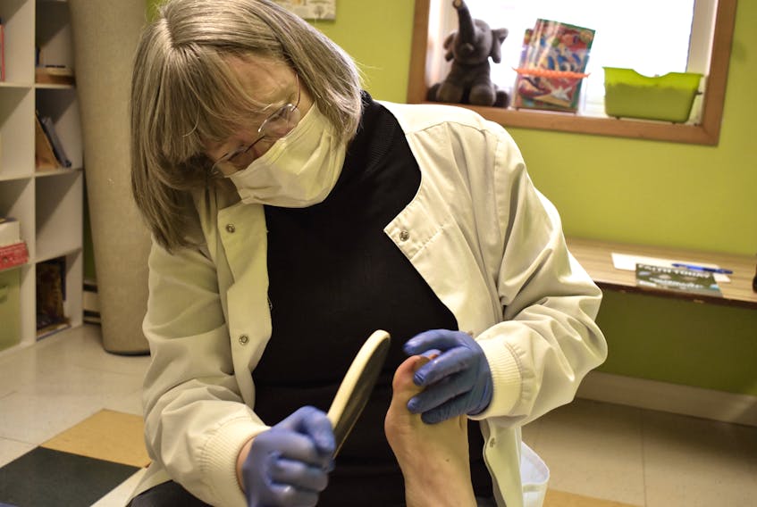 Shirley Spence examines a callus on a client’s great toe at her free foot care clinic at the Summerside Baptist Church. Alison Jenkins/ Journal Pioneer.