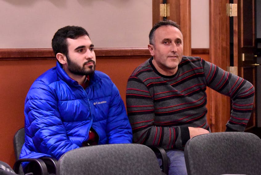 Rilind Musliu, left, sits with his dad, Kujtim Musliu, at a special Summerside council meeting held for the public to discuss the six-unit townhouse Kujtim wants to build on MacEwen Road.