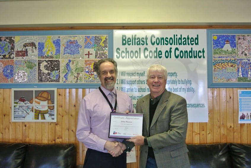 Garth Wade presents Belfast principal John Munro with a certificate of appreciation.