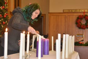 A young woman lights a candle during the annual National Day of Remembrance and Action on Violence Against Women Service Tuesday at Summerside Presbyterian Church.