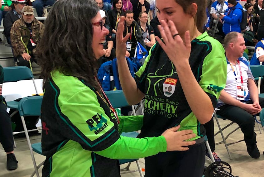 Kristen Arsenault and her mother and manager, Michelle Arsenault, share an emotional moment at the 2019 Canada Winter Games in Red Deer, Alta., on Thursday. Arsenault won a silver medal in compound archery.