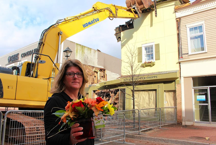 Cindy Robichaud, owner and manager of Kelly’s Flower Shoppe stood and tearfully watched as the store’s former location in Summerside, was demolished on Tuesday. (Millicent McKay/Journal Pioneer)
