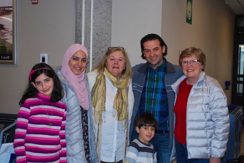 Hala Albrzawi, left, mom Maldaa Al Nahas Alhomsi, Patricia Bennett, Kenan Albrzawi, Mohammed Albrzawi and Carolyn Francis pause for a welcome-to-P.E.I. moment in the Charlottetown airport after the Syrian family arrived here recently. -Submitted photo/Patricia Bennett