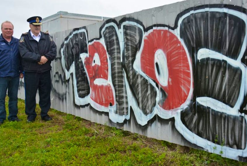 Dave Ellis, a youth outreach worker, left, and Summerside Police Chief Dave Poirier with a graffiti tag scrawled on private property. Summerside has seen a recent upswing in the frequency of graffiti vandalism, but police believe they are close to charging someone.