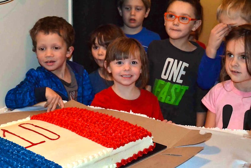 Eager students look on as an anniversary cake is set before them. It was all part of an celebration marking 10 years since the opening of École Pierre-Chiasson and Centre acadien de Prince-Ouest in DeBlois.