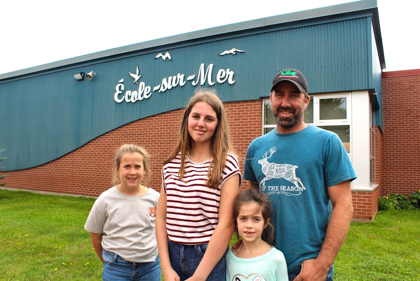 Cory Adams and his three youngest children, from left, Morgan Gaudet and Storm and Paisley Adams. Morgan recently made the switch from the English language school system to the French system, which recently topped 1,000 students for the first time. She attends Grade 8 at École-sur-Mer in Summerside while her sisters attend Grade 4 and 2 at École Évangéline in Abram-Village.