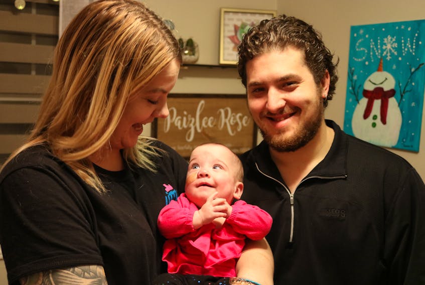 Paizlee Rose Adams, centre, seven-months, smiles up at her mom Emily McCardle and father Andy Adams. The happy parents brought their daughter home at the end of October after spending several months in various hospitals. Paizlee was born at 23 weeks at the IWK Health Centre in April.