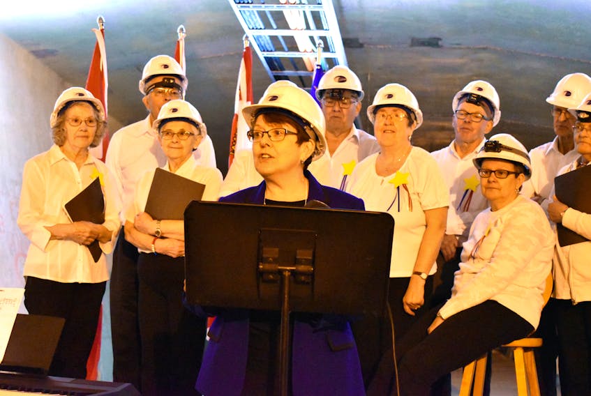 Claudette Theriault, president of the Congres Mondial acadien 2019, speaks at a news conference inside the Confederation Bridge on May 21. Behind her are some of the members of Chorale Notre-Dame du Mont Carmel.
