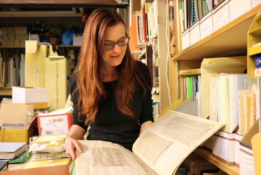 Nikkie Gallant, site director of Eptek Arts and Culture Centre, browses the pages of old Eptek notices published in the 1980s informing people of the travelling exhibitions that the centre was hosting.