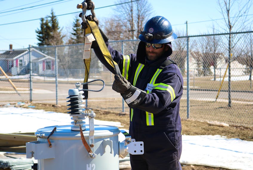 Brody Cahill hooks straps onto a transformer in the yard of the Summerside Electric utility. Crew members were moving transformers in the yard Tuesday afternoon.