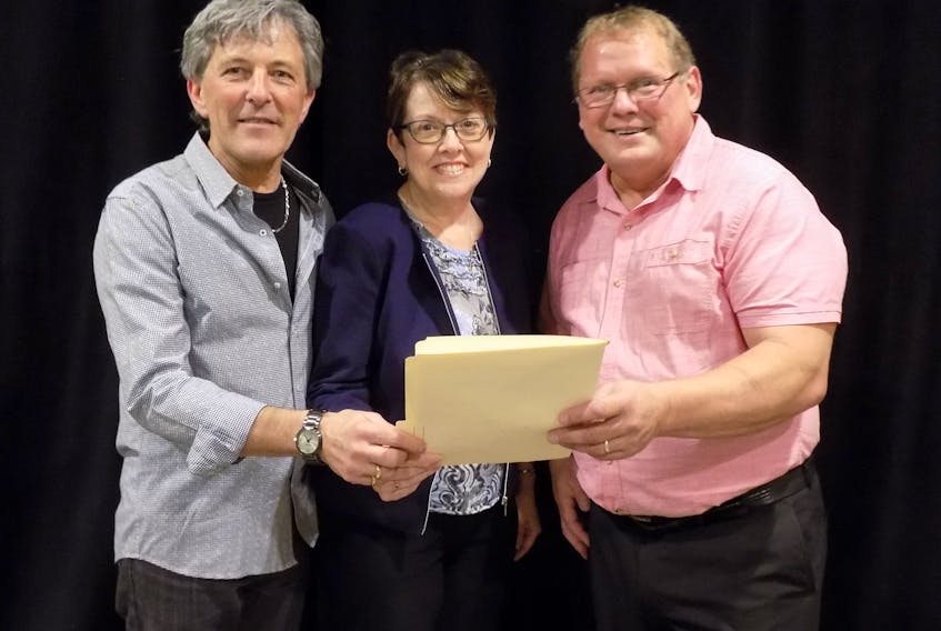 Claudette Thériault, who will chair the Dec. 14 public meeting for the Chez-Nous Co-op, discusses the meeting agenda with president Marcel Richard, left, and executive director Edgar Arsenault.