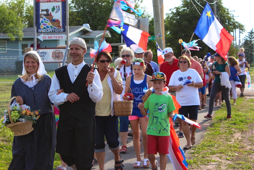 The traditional Acadian characters of Evangeline and Gabriel leading a tintamarre or "noise parade" through Abram-Village on National Acadian Day.