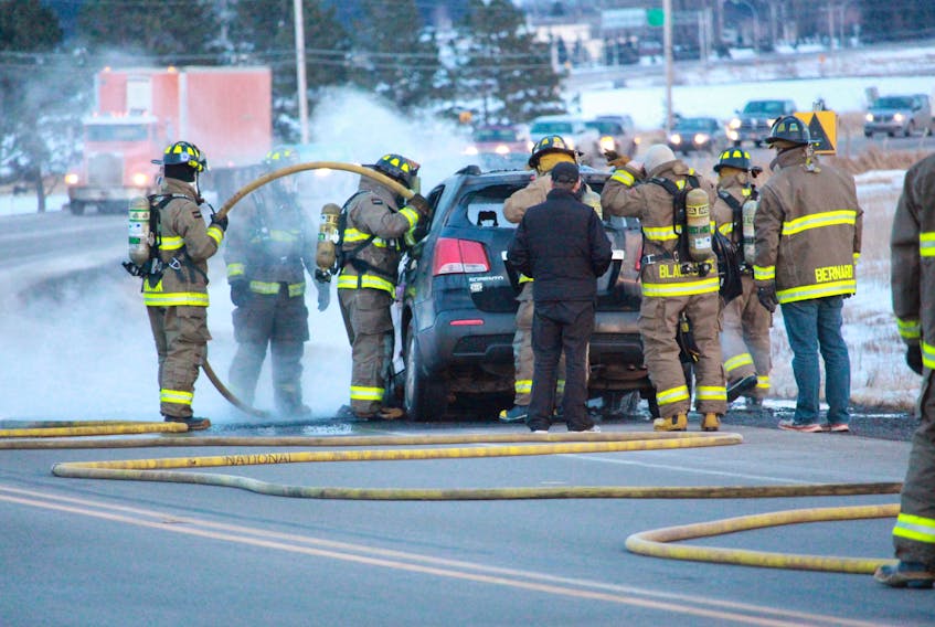 Members of the Summerside Fire Department quickly go t work to extinguish a car fire Monday evening on Route 2 in Traveller’s Rest.