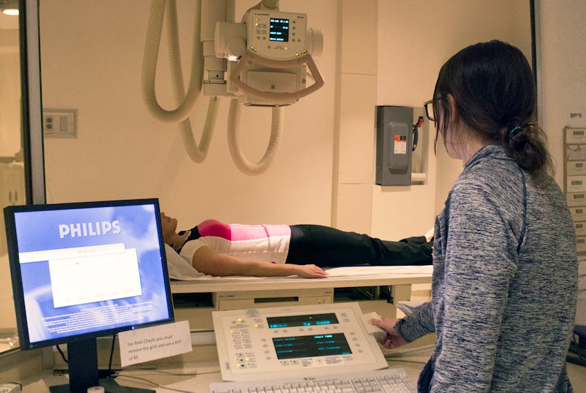 The current Digital Radiography machine (X-Ray) is demonstrated on a patient by technologist Renée Franc.