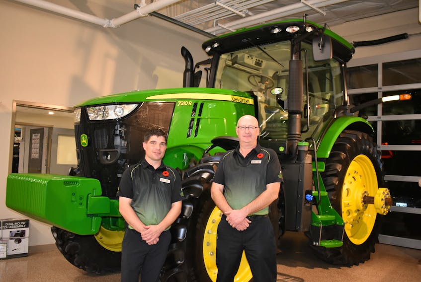 Long-term employees Colin Pearce, left, corporate aftermarket manager, and Jeff Wood, Summerside store manager pose for a photo at the grand re-opening of the Green Diamond Equipment dealership in Summerside.