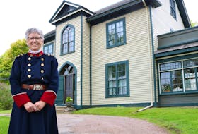 Katherine Dewar, wears a replica of the nursing uniform Georgina Fane Pope designed for the Canadian Army Nursing Core. The house in the background, was the last residence Pope had in Summerside, where she lived with the mother and other family members. It sits on the Corner of Fitzroy and Granville Streets.