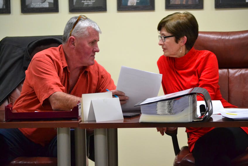 David Gordon confers with chief administrative officer Susan Wallace-Flynn during his first meeting as mayor of Alberton. The new mayor won support from his council when he suggested the school breakfast program at Alberton Elementary School would be a good place for a $300 Christmas donation.