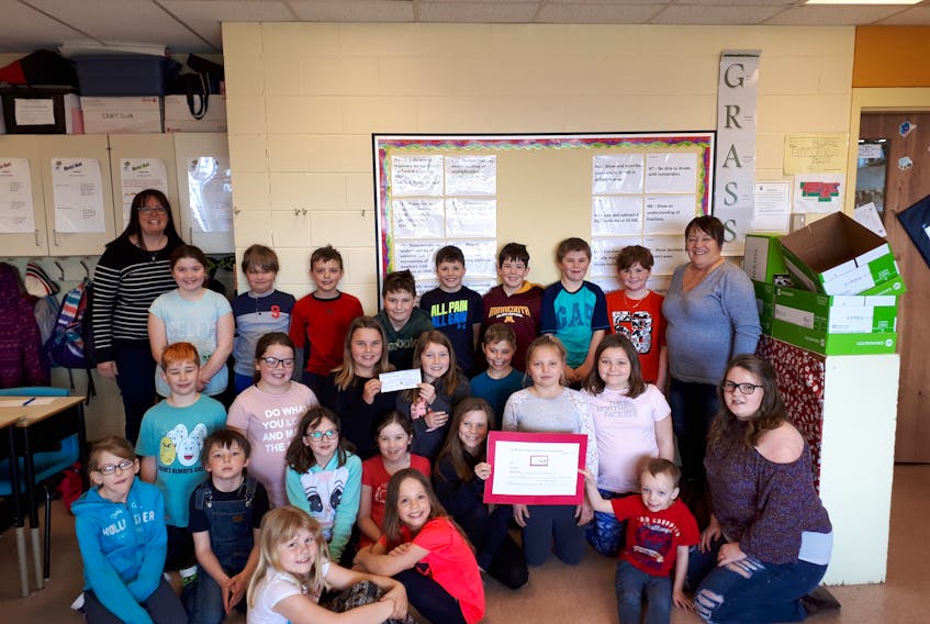 Kathy Wright, back right, along with her niece Ellen Wright, front right, and great nephew Tristan, present the $1000 cheque to Sharon Anderson, left, and her Grade 3/4 class at Somerset Elementary on Wednesday. -Bryce Doiron photo